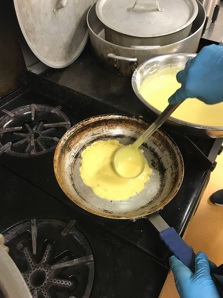 skillet on a commercial oven with egg yolk crepe batter