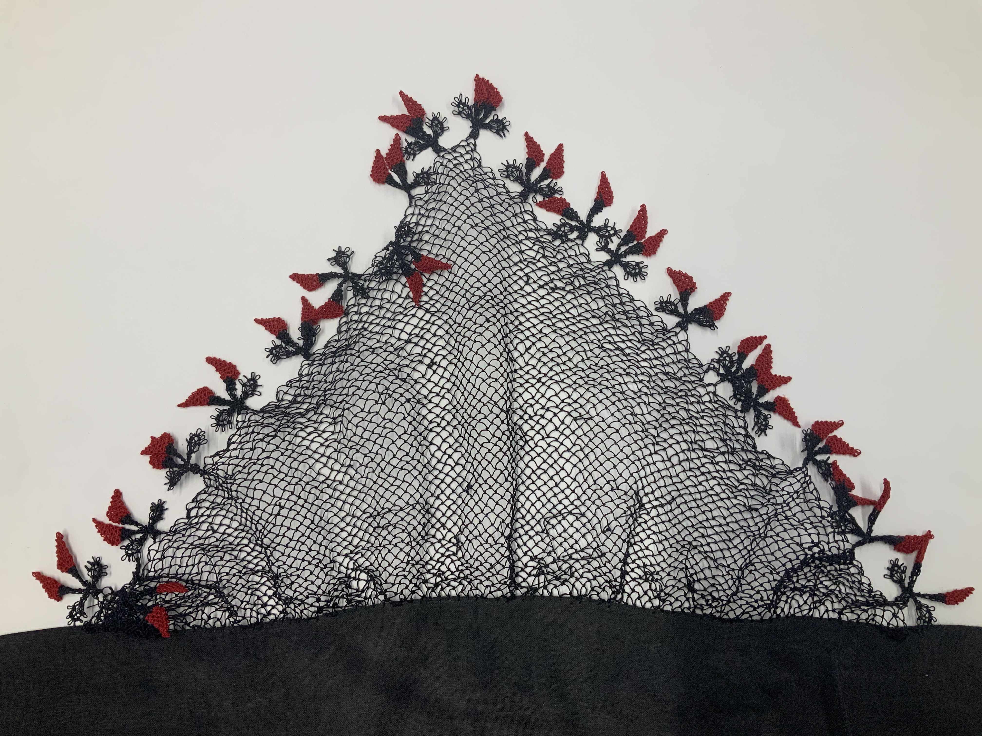 A triangular oya needle lace with black netting and red pepper style decorative embroidery details adorning the outer edges