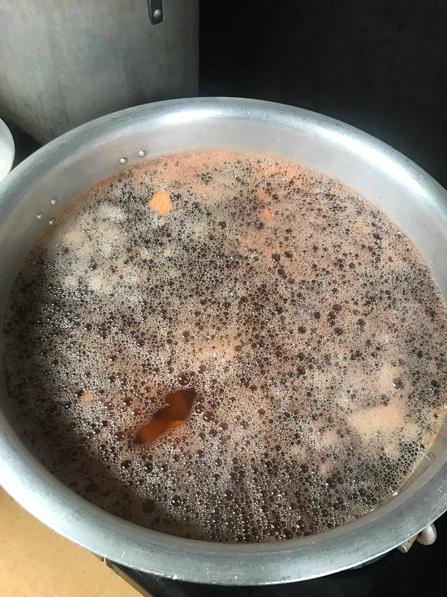 the same saucepan with a a new liquid inside that appears to be less viscous than the previous two images, and brownish in colour. a few tapioca pearls are visible at the bottom of the pan