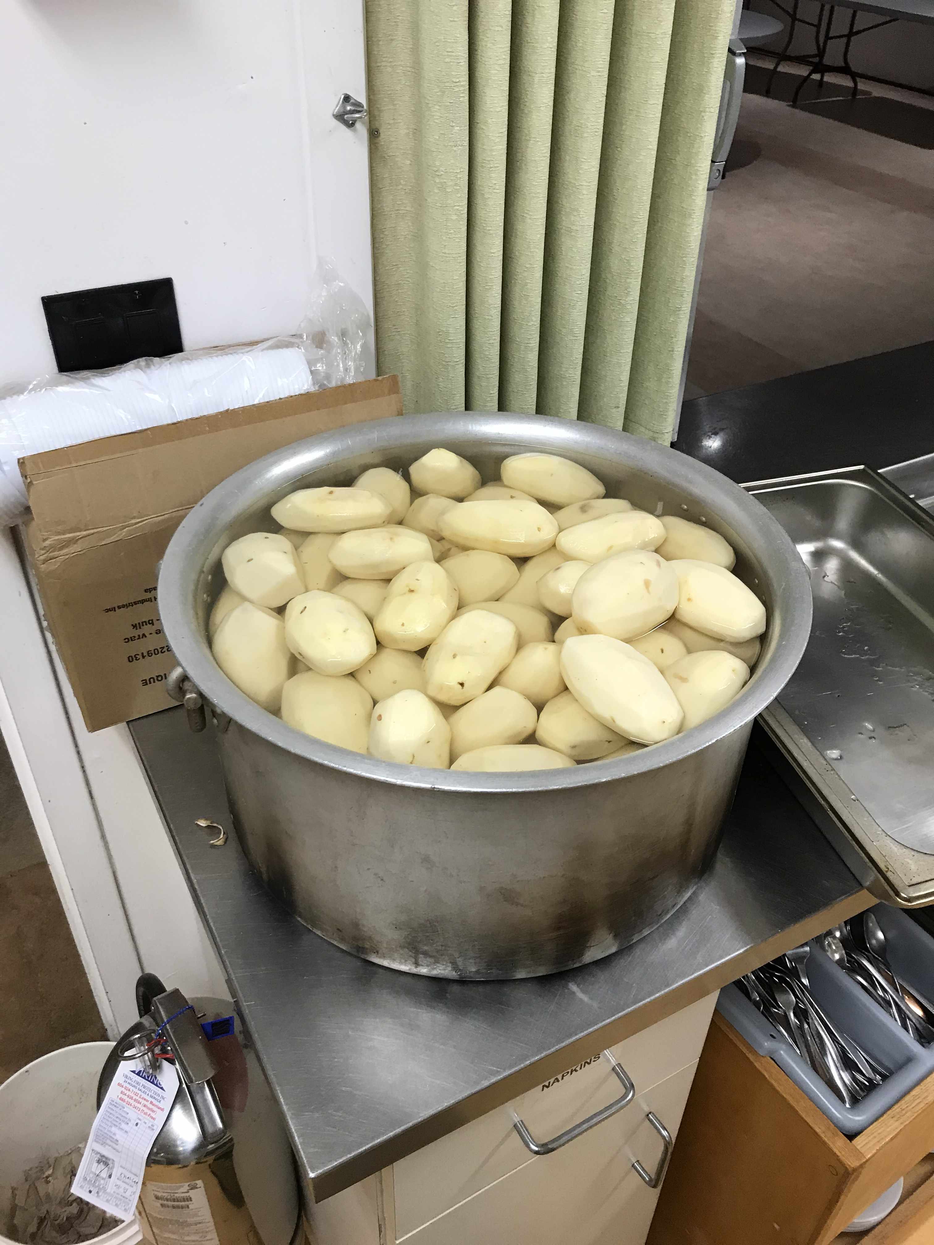 40 litre pot full of peeled potatoes standing on the countertop