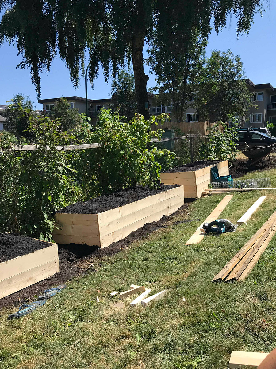three newly built garden beds topped with soil. each bed is about 10 feet long, and 4 feet wide. their hights vary 16, 24 and 32 inches from the ground. the beds are outside of the fence of sahalli park community garden.